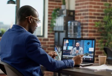Company employee attending remote videocall meeting with man Company employee attending remote videocall meeting with man on laptop, having conversation on webcam. Talking to manager on online teleconference call, internet telework communication.